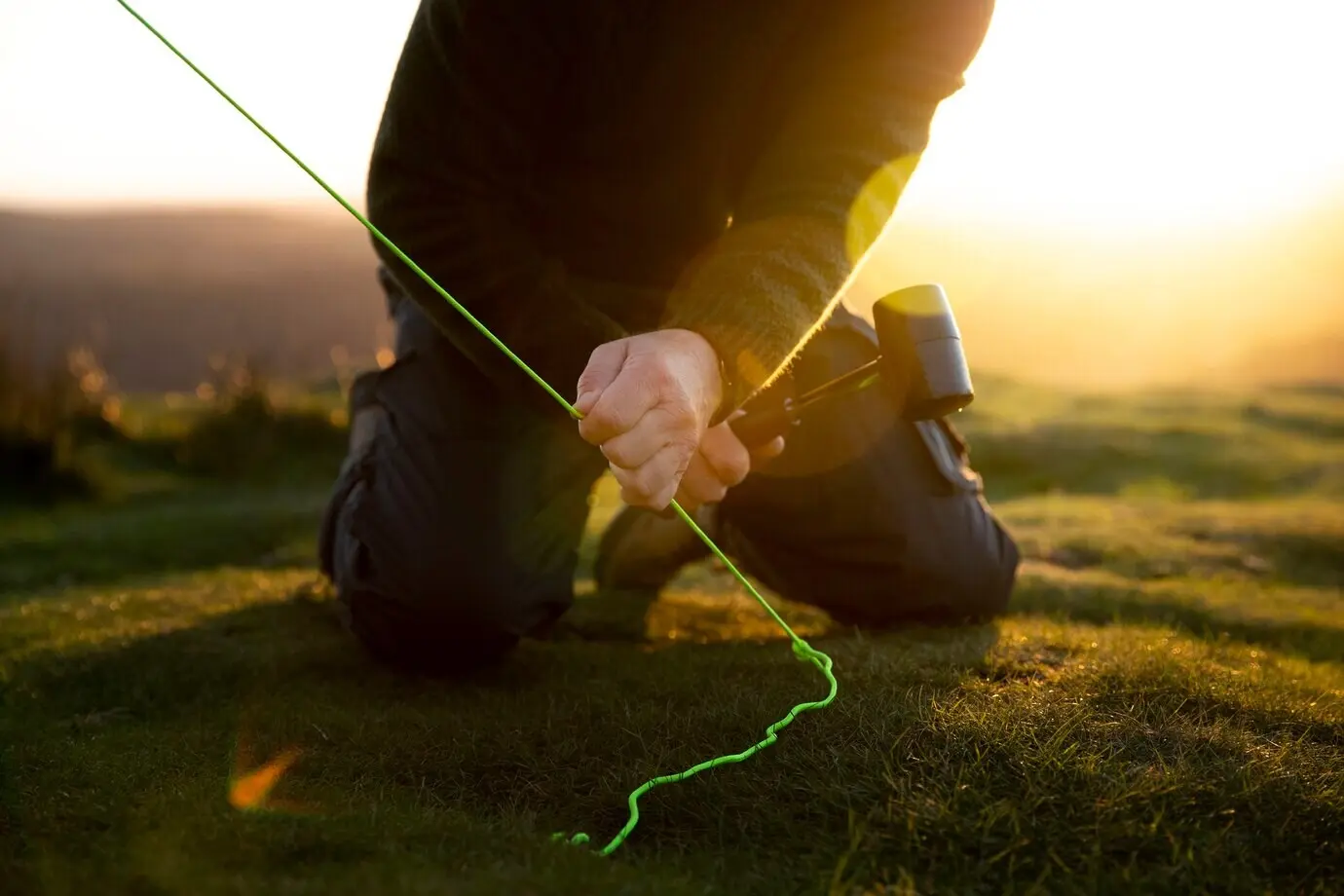 Close-up of hands pitching a tent.